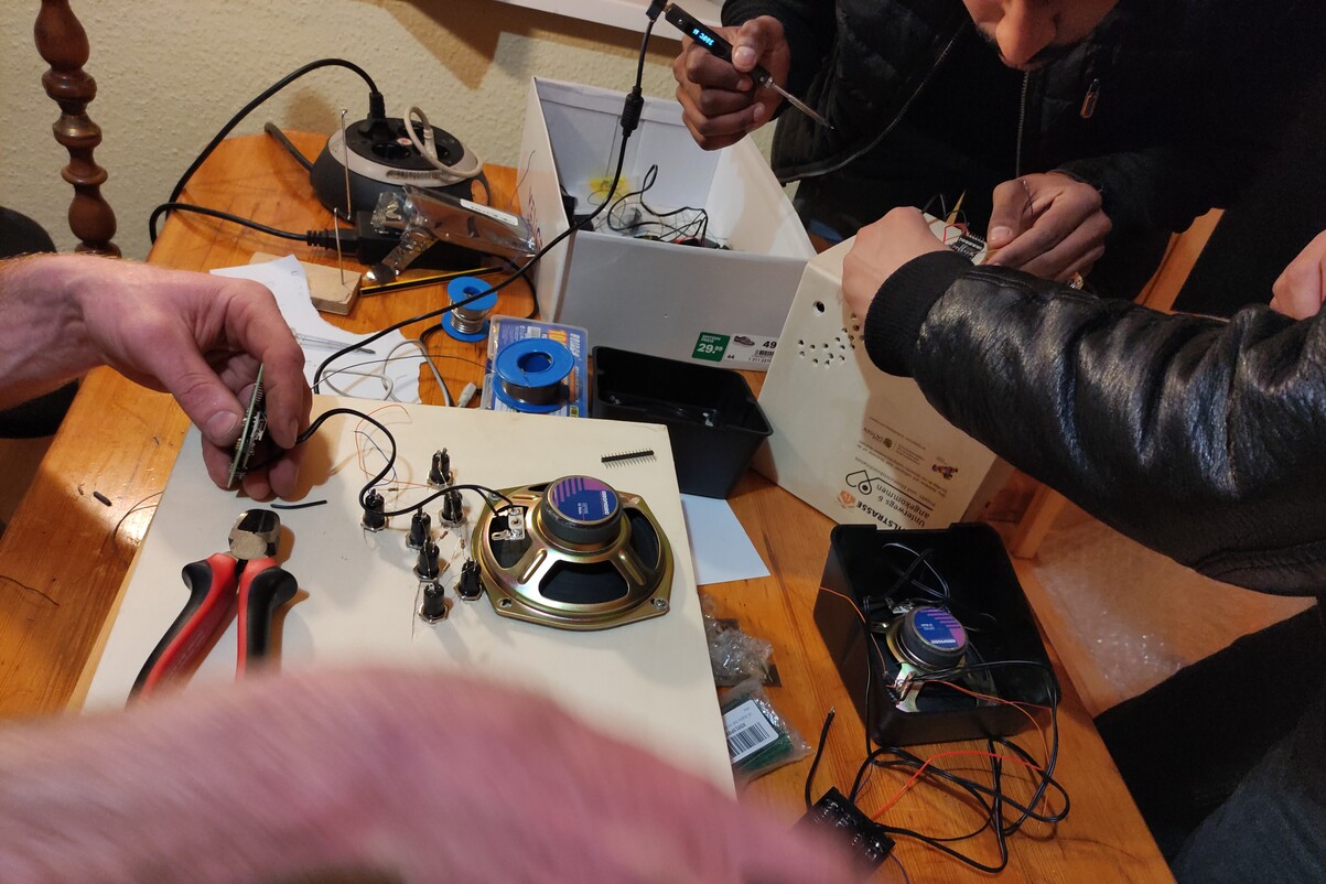 Hände und Mikroelektronik sind zu sehen. Es wird gebaut und gelötet.